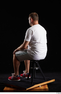 Louis  2 dressed grey shorts red sneakers sitting sports…